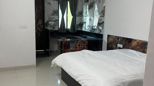 a bedroom with a white bed and a desk at The Seven Suites - Fort View in Chittaurgarh