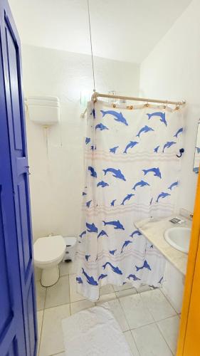 a bathroom with a shower curtain with dolphins on it at Pousada Café e Prosa Centro Histórico Paraty in Paraty