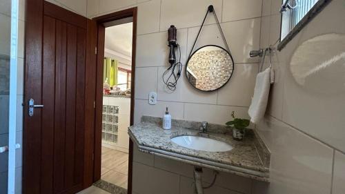 a bathroom with a sink and a mirror on the wall at Casa com Piscina Privativa e Churrasqueira in Araruama
