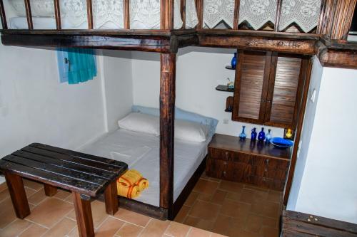 a bedroom with a bunk bed with a bench and a table at Glaros in Pera Gyalos