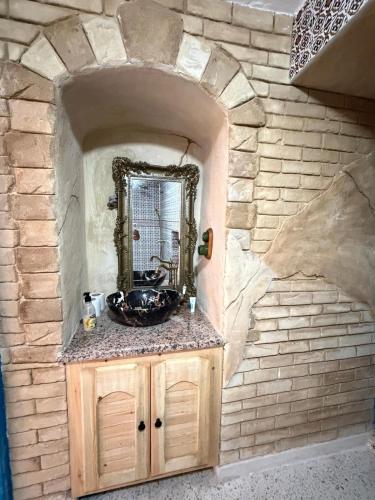 a bathroom with a sink in a stone wall at Dar Sarah in Kelibia