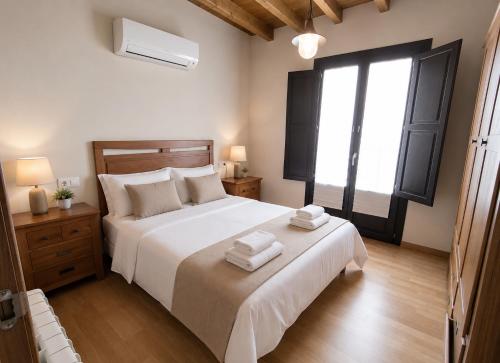 a bedroom with a large white bed with towels on it at Casa dos Acevedo in Verín