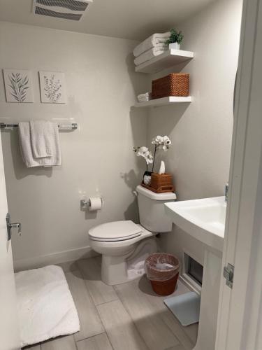a white bathroom with a toilet and a sink at Private Dana Point Beach Studio in Dana Point