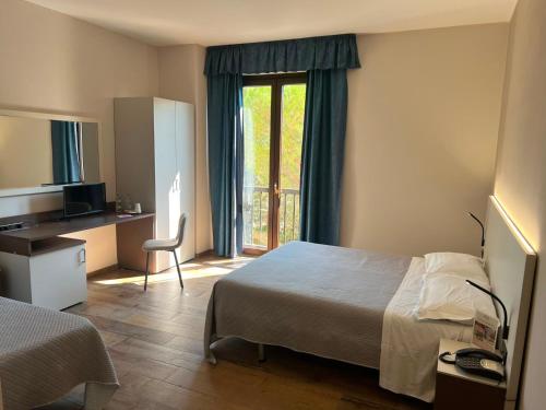 a hotel room with a bed and a window at Il Grifo Hotel e Bisteccheria Toscana in Montepulciano