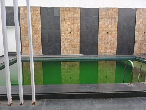 a swimming pool in front of a building at Adory homes inn in Kelambākkam