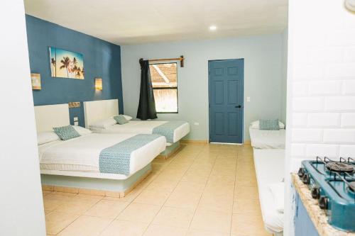 two beds in a room with blue walls at Hotel Bungalows Marbella Costa Esmeralda in Monte Gordo