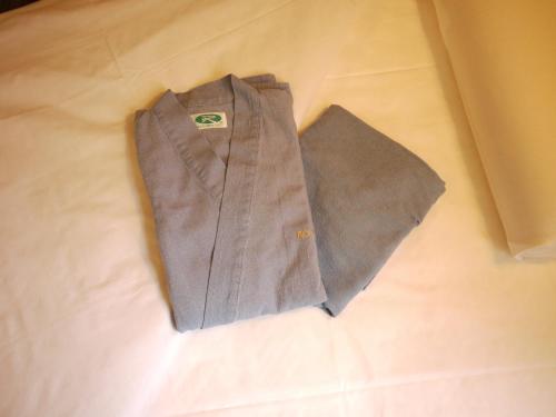 a brown shirt and tie sitting on a bed at Hotel Route-Inn Takaoka Ekimae in Takaoka