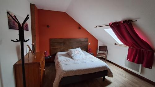 a bedroom with a bed and a red wall at La Maillitardaise - Table d'Hôte in Saint-Pierre-de-Fursac