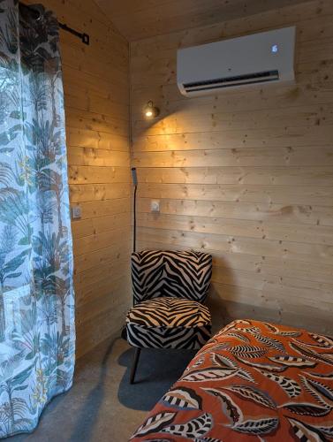 a room with a bedroom with a bed and a fan at Chic and Chill Guest House, gite Safari in Vallon-Pont-dʼArc