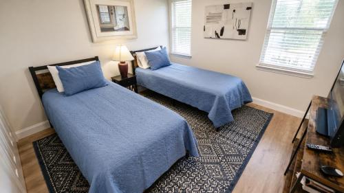a bedroom with two beds with blue sheets and a rug at 2Br 2Ba Condo on Golf Course in Pawleys Island