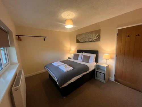 a bedroom with a bed with two pillows at Saddleback Bungalow in Llandrindod Wells