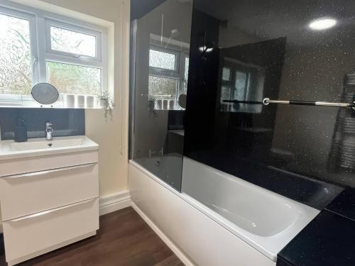 a bathroom with a tub and a sink and a shower at Saddleback Bungalow in Llandrindod Wells