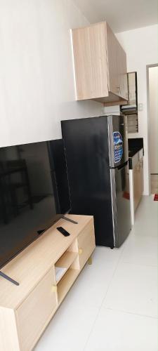 a kitchen with a black refrigerator and wooden cabinets at Graceland in Lapu Lapu City