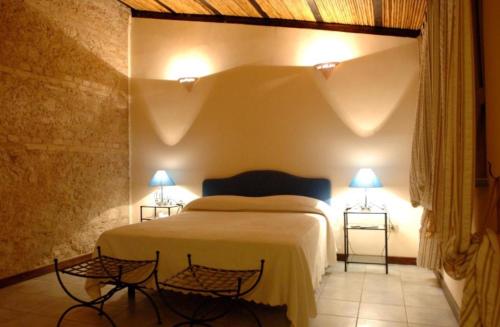 a bedroom with a large bed with two lamps at Il Pero Selvatico in Borgia