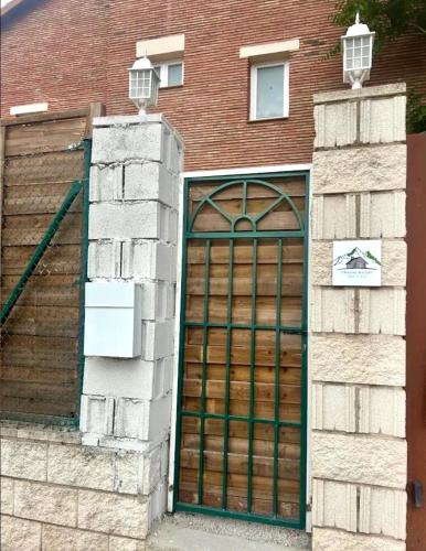 a building with a large wooden garage door at El Rinconcito de La Suiza in Robledo de Chavela