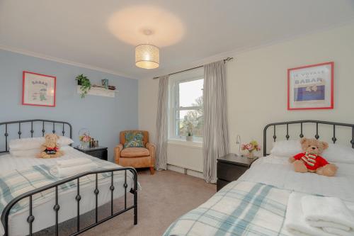 two teddy bears sitting on two beds in a bedroom at Three Peaks Central Cottage, Settle, 3Bed 2Bath in Settle