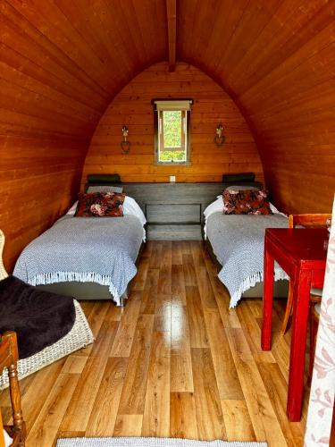 a bedroom with two beds in a wooden room at Buitengewoon Overnachten in Terheijden