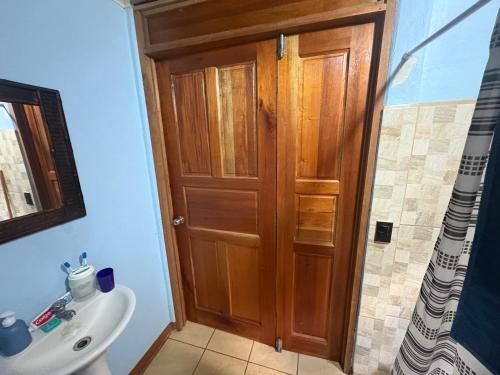 a bathroom with a wooden door and a sink at Elsie Place in San Mateo
