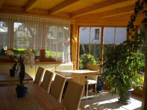 a dining room with a table and chairs and windows at Apartment Könighaus in Sankt Michael im Lungau