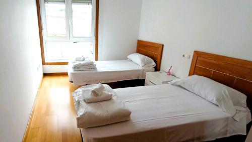 a room with two beds and a window at EnSAN CIPRIAN Playas y Relax in San Ciprián