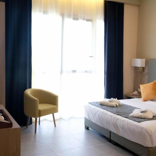 a bedroom with a bed and a yellow chair at EVASION by LIBERTE in Oran