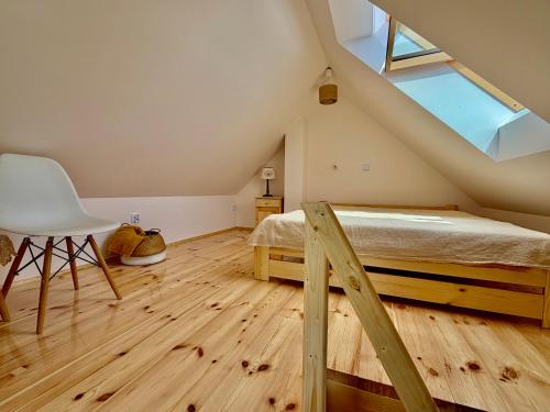 a bedroom with a bed and a chair in a attic at Agroturystyka Evita in Jabłeczna