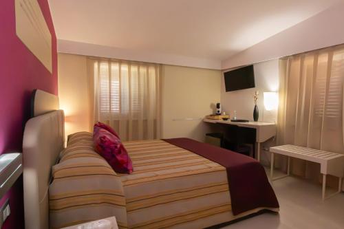 a hotel room with a bed and a desk at Resid Enza Palazzo Sciacca in Patti