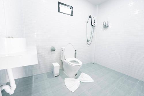 a white bathroom with a toilet and a shower at NS Khaolak Resort in Khao Lak