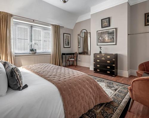 a bedroom with a large bed and a desk at Raphael Rooms in Peterborough