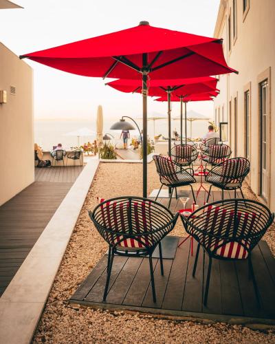 a group of chairs and a red umbrella on a deck at Memmo Alfama - Design Hotels in Lisbon