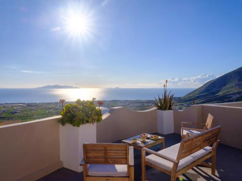 a balcony with a table and chairs and a view of the ocean at Themis Goddess Cave Suites in Santorini