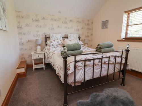 a bedroom with a bed with a metal frame at Ash Farm Cottage in Holywell
