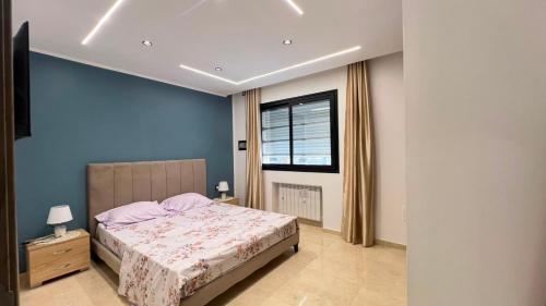 a bedroom with a large bed and a window at Superbe appartement Khezama in La Corniche
