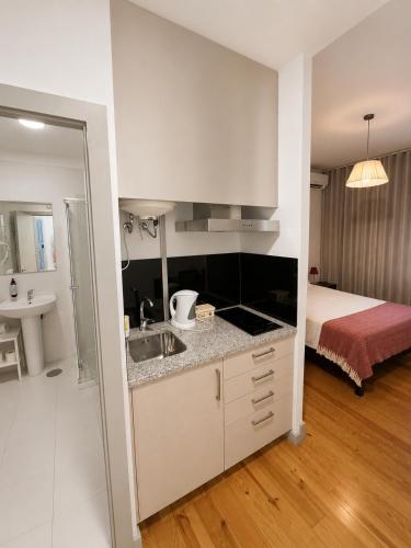 a kitchen with a sink and a bed in a room at Guest House Vimaranes in Guimarães