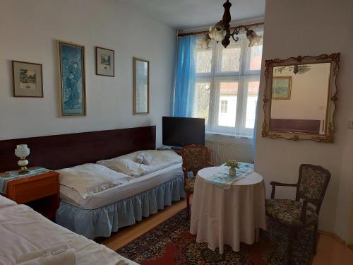 a bedroom with a bed and a table and a mirror at Hotel Garni in Ostrava