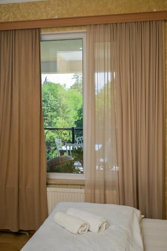 a bedroom with a window with two towels on a bed at Kutaisi Grand Suites in Kutaisi