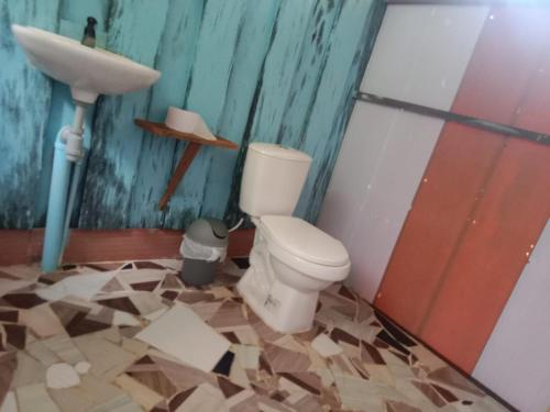 a bathroom with a toilet and a sink at Cabaña Perla del Cabo in Nuquí