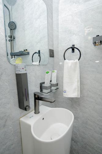 a white bathroom with a sink and a mirror at IGAWILO RESIDENCE Hotel in Dodoma