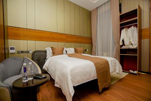 a hotel room with a bed and a chair at IGAWILO RESIDENCE Hotel in Dodoma