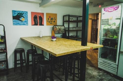 a kitchen with a bar with stools and a refrigerator at 531 Hostel in Cordoba