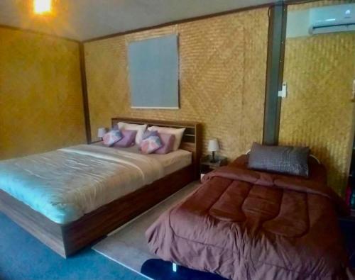 a bedroom with two beds and a window at Alisa Villa, Ubon Cottage in Ban Pla Duk