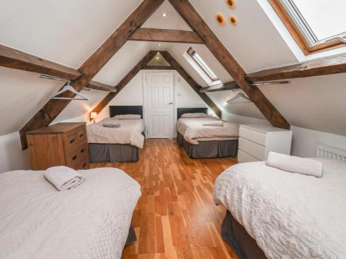 a attic room with three beds and a window at Reighton House in Filey