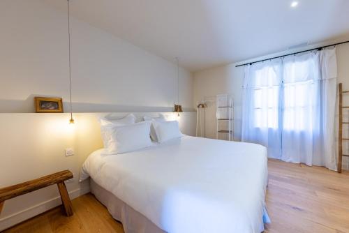 a bedroom with a large white bed and a window at Domaine Croix-Maro in Caux