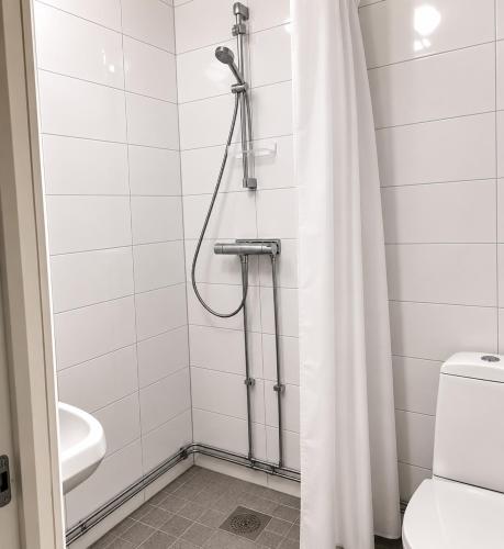 a bathroom with a shower curtain and a toilet at Bokloster Longstay in Märsta