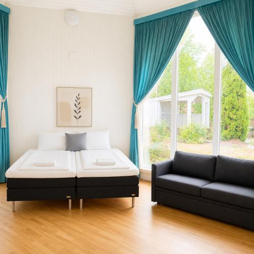 a bedroom with a bed and a couch and a window at Bokloster Longstay in Märsta