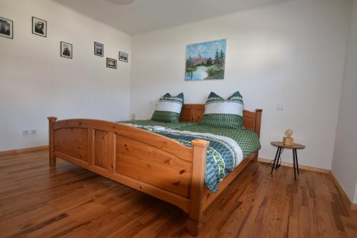 a bedroom with a wooden bed with green and white pillows at Ferienwohnung Barthel in Merzig