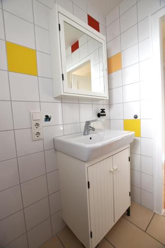 a bathroom with a white sink and a mirror at Ferienwohnung Barthel in Merzig