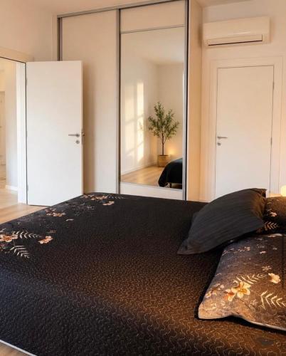 a bedroom with a large mirror and a bed at Sun House in Kumbor