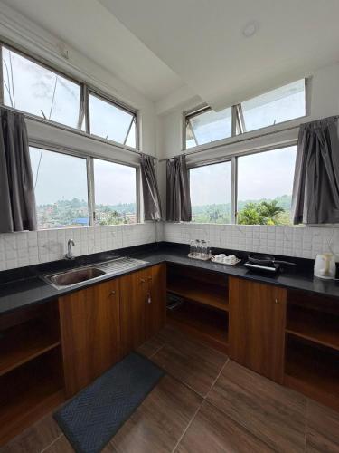 a kitchen with two sinks and two windows at Kesang Stay in Diphu