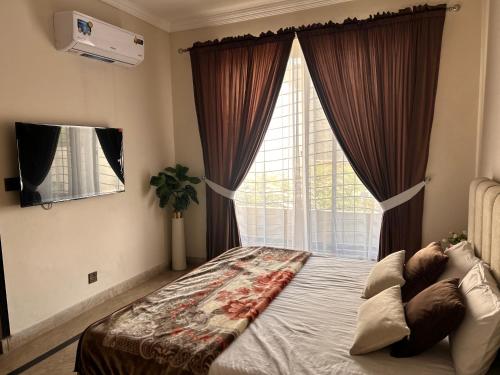 a bedroom with a bed with a large window at Mohib Home Stay in Lahore
